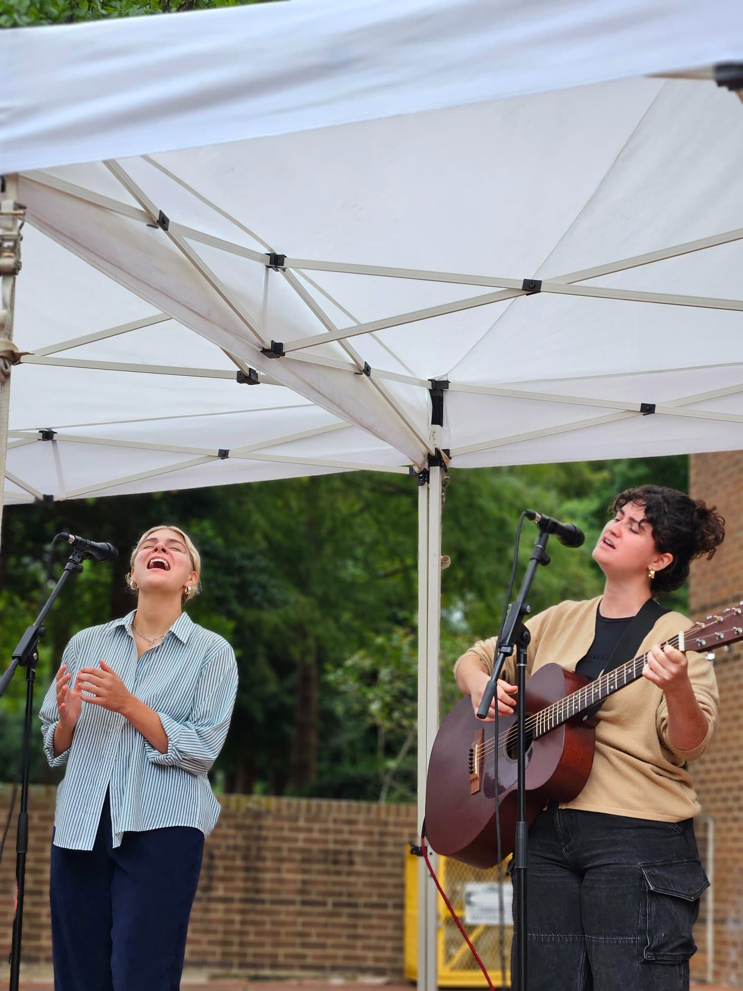 A vocalist and guitarist performing outdoors at the Wellness HUB Raleigh